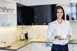 © NDABCREATIVITY - Beautiful woman holding a cup in a kitchen