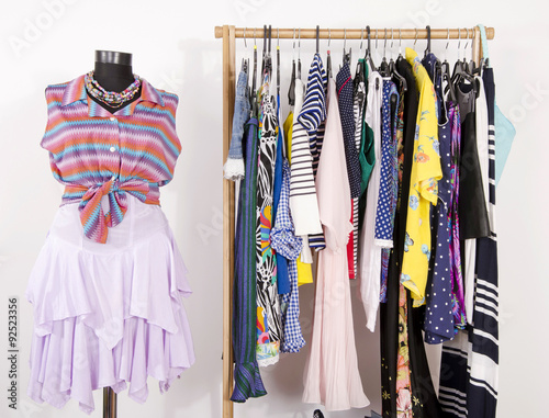 Dressing Closet With Colorful Clothes Arranged On Hangers And A