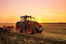 Tractor On The Barley Field By Sunset.