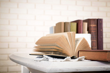 Poster - Heap of old books on brick wall background