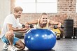 © WavebreakMediaMicro - Male trainer helping young woman with the dumbbells