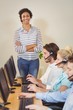 © WavebreakmediaMicro - Smiling businesswoman with arms crossed standing at employees