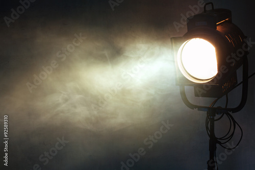 Poster theater spot light with smoke against grunge wall
