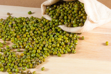 Green bean in sack on wood background