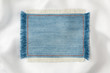 Frame made of denim fabric with yellow stitching on white silk
