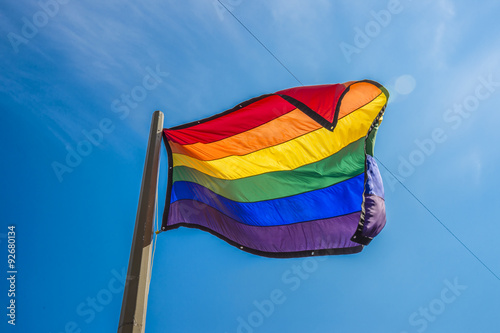 Fotografía Gay rainbow flag waving over blue sky background
