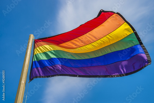 Fotografía Gay rainbow flag waving over blue sky background