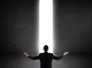 Business person looking at wall with light tunnel opening