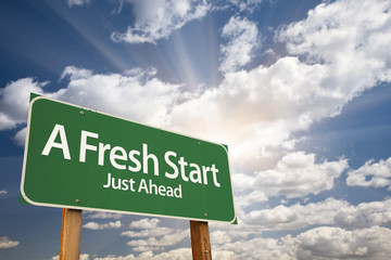 Wall Mural - A Fresh Start Green Road Sign Over Clouds