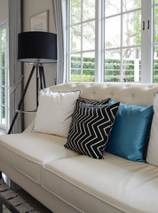 white and blue pillows on a white leather couch in vintage living room