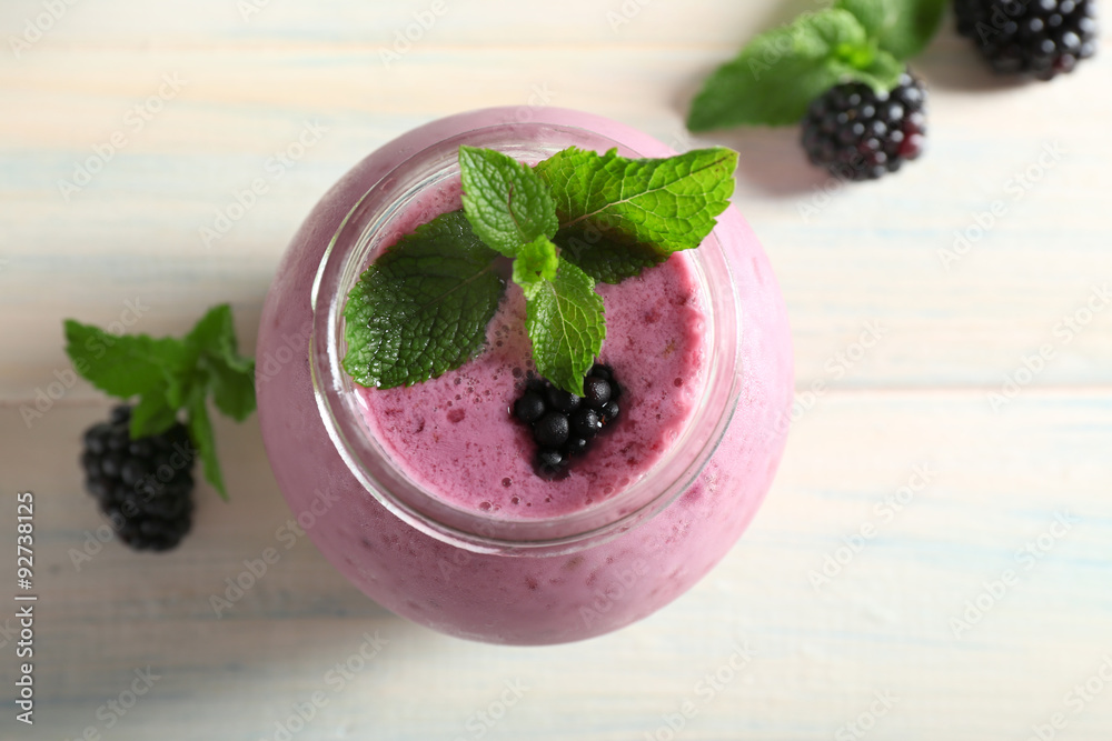 Delicious berry smoothie with blackberries on wooden table close up