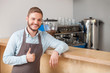 Cheerful male cafe worker is expressing positive emotions