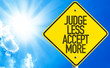 Judge Less Accept More sign with sky background