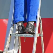 Repair. The Worker's Feet In A Uniform On A Step-ladder.