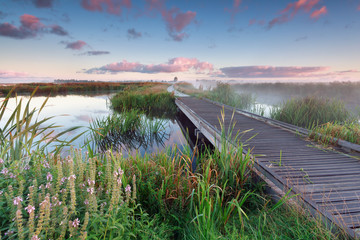 woodem bike path on lake water at sunrise