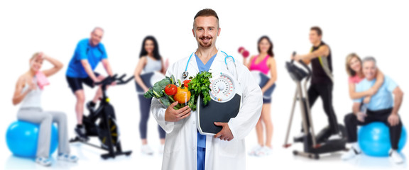 Doctor with vegetables and group of fitness people.