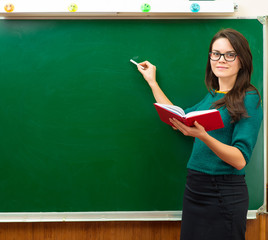 Teacher near blackboard in the classroom