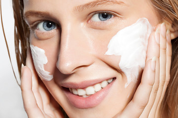 Close-up of a woman put the cream on the skin