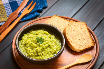 Wall Mural - Homemade zucchini and parsley spread garnished with parsley, wholegrain bread on the side, photographed with natural light (Selective Focus, Focus on the leaf)