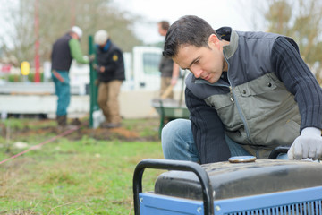 Builder turning on an air compressor