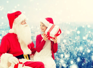 Canvas Print - smiling little girl with santa claus and gifts