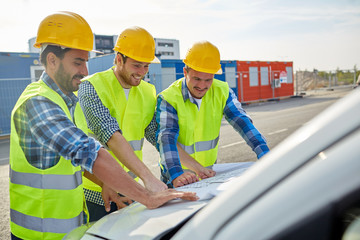 Poster - close up of builders with blueprint on car hood