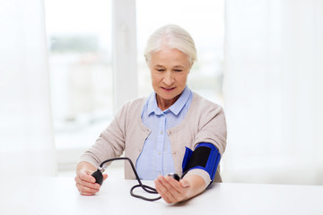 Sticker - old woman with tonometer checking blood pressure