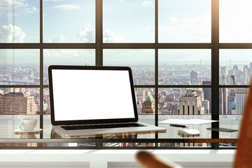 Mock up of blank laptop on the desk in office with city view