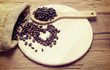 Coffee beans small wooden spoon on the wood with heart backgroun