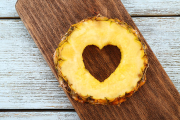 Poster - Pineapple slice with cut in shape of heart on wooden background