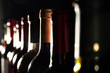 chilled wine bottles in a row on black background
