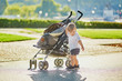 Cute little boy pushing his stroller