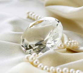 large glass diamond and pearl necklace on a soft silk background