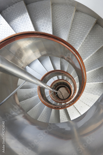 Obraz w ramie Metallic spiral stair with wooden handrails inside a lighthouse