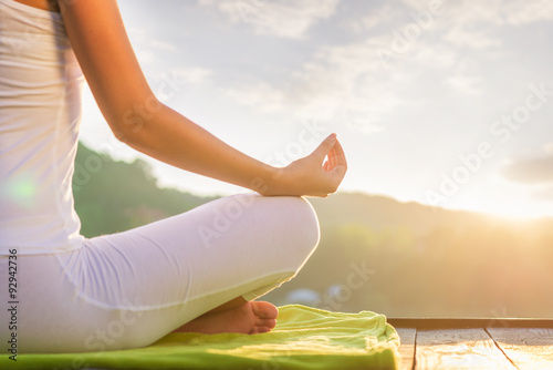 Fotografia Woman doing yoga on the shore - half figure sitting