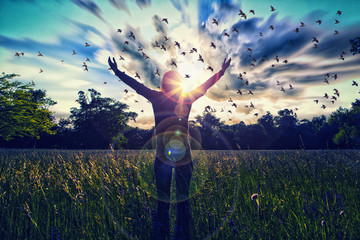 Young girl spreading hands with joy and inspiration facing the sun,sun greeting,freedom concept,bird flying above sign of freedom and liberty