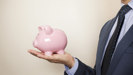 Business man holding a piggy banck