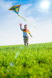 © mr.markin - Young boy playing with his kite in a green field.