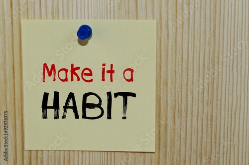 Fotografia Make it a habit written on paper note over wooden background
