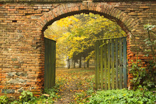 Old Brick Gate Opened To The Autumn Misty Park