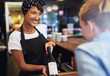 © Flamingo Images - Smiling waitress or bartender showing red wine