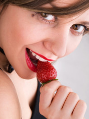 Canvas Print - Young woman eating strawberry