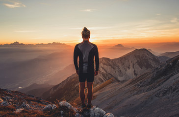 Male hiker observing the sunset at the top of the local big mountain. The photograph was taken in Karavanke mountain range in Slovenia.