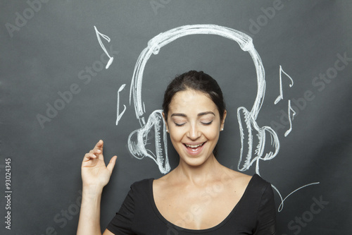 Foto Junges und schönes Mädchen simuliert das Hören auf ein Musikstück, das hinter de