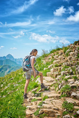 Wall Mural - Young woman backpacking in the mountains