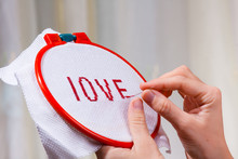 Hands Embroidering A Word Love
