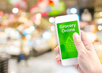 Poster - Hand holding mobile with grocery online on screen with blur supe