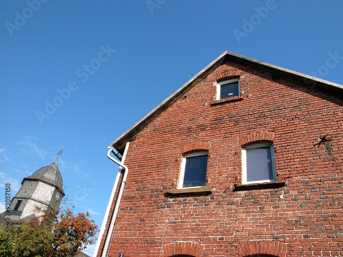 Altbau mit Fassade aus rotem Backstein und Turm der evangelischen