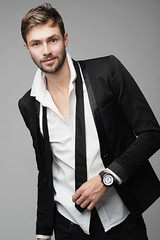 Portrait of a beautiful and stylish men in suit posing in studio