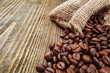 Coffee beans in sackcloth bag on wooden table. Close up. Selective focus